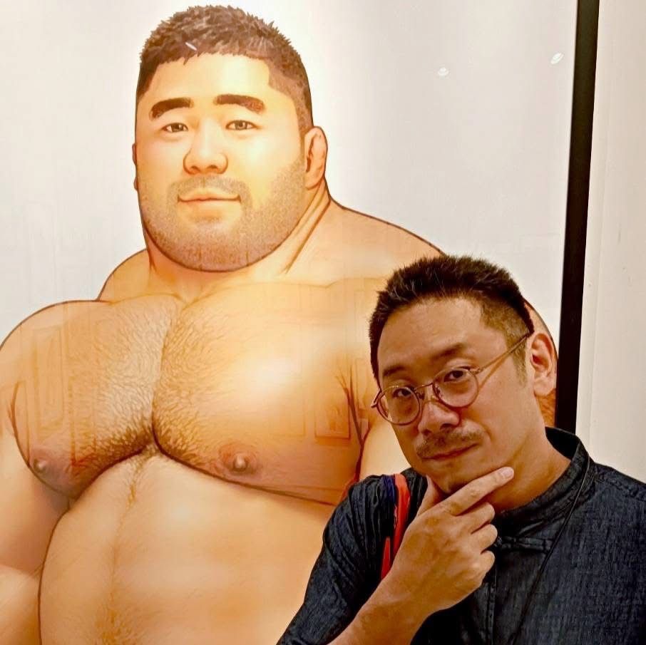 児雷也さんの絵の隣でポーズをとる東海林監督