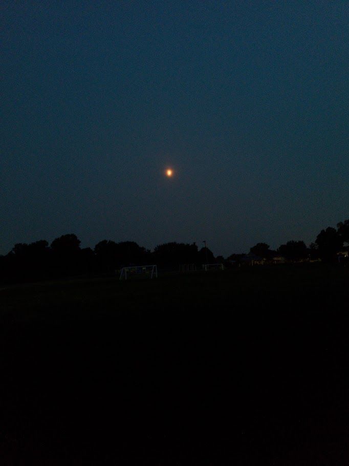 Moon seen from a walk on the evening of August 4, 2025 showing the impact of smoke from wildfires - there is a reddish haze surrounding the Moon. Photo taken by the post's author in Guelph, Ontario, Canada.