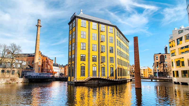 Riverfront view of historic industrial buildings in Norrköping, Sweden