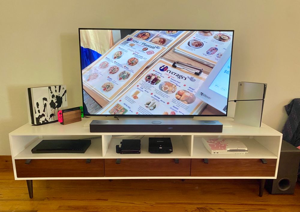 TV sitting on a media console with various game systems attached.