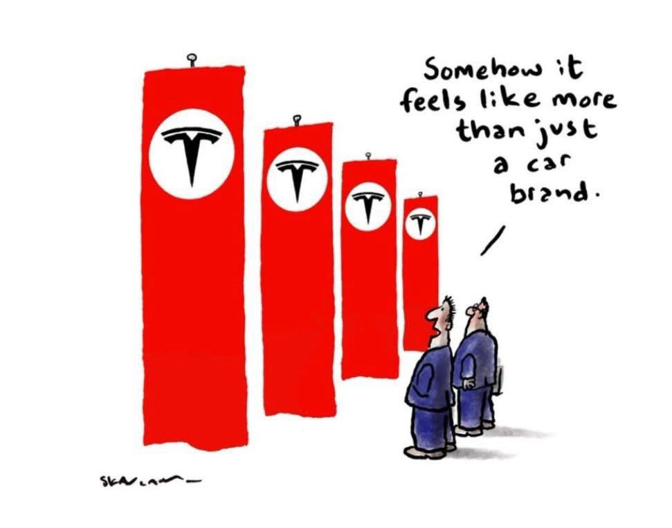4 long, vertical and narrow red flags with black Tesla logos on them, resembling a uniform display. two men in blue suits stand nearby, looking at the flags. one says, “somehow it feels more than just a car brand.”