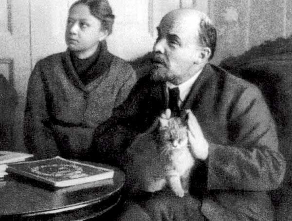 Lenin with a kitty in his lap. He is covering the cats ears 