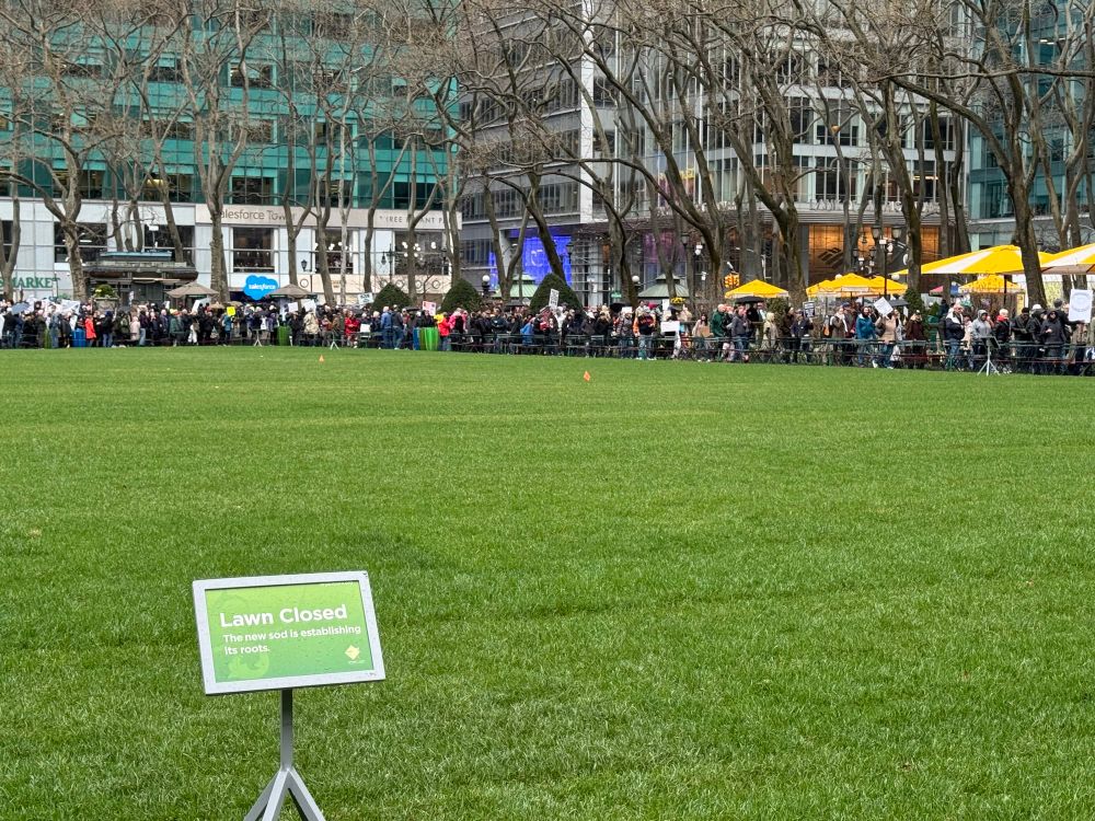 Empty lawn surrounded by crowd at bryant park in nyc 
