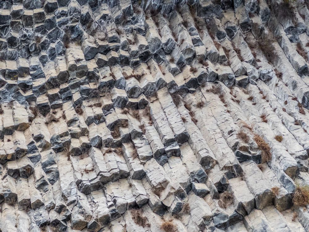 A frame filled with angled columns of basalt. The columns flow uniformly diagonally, displaying their hexagonal shape