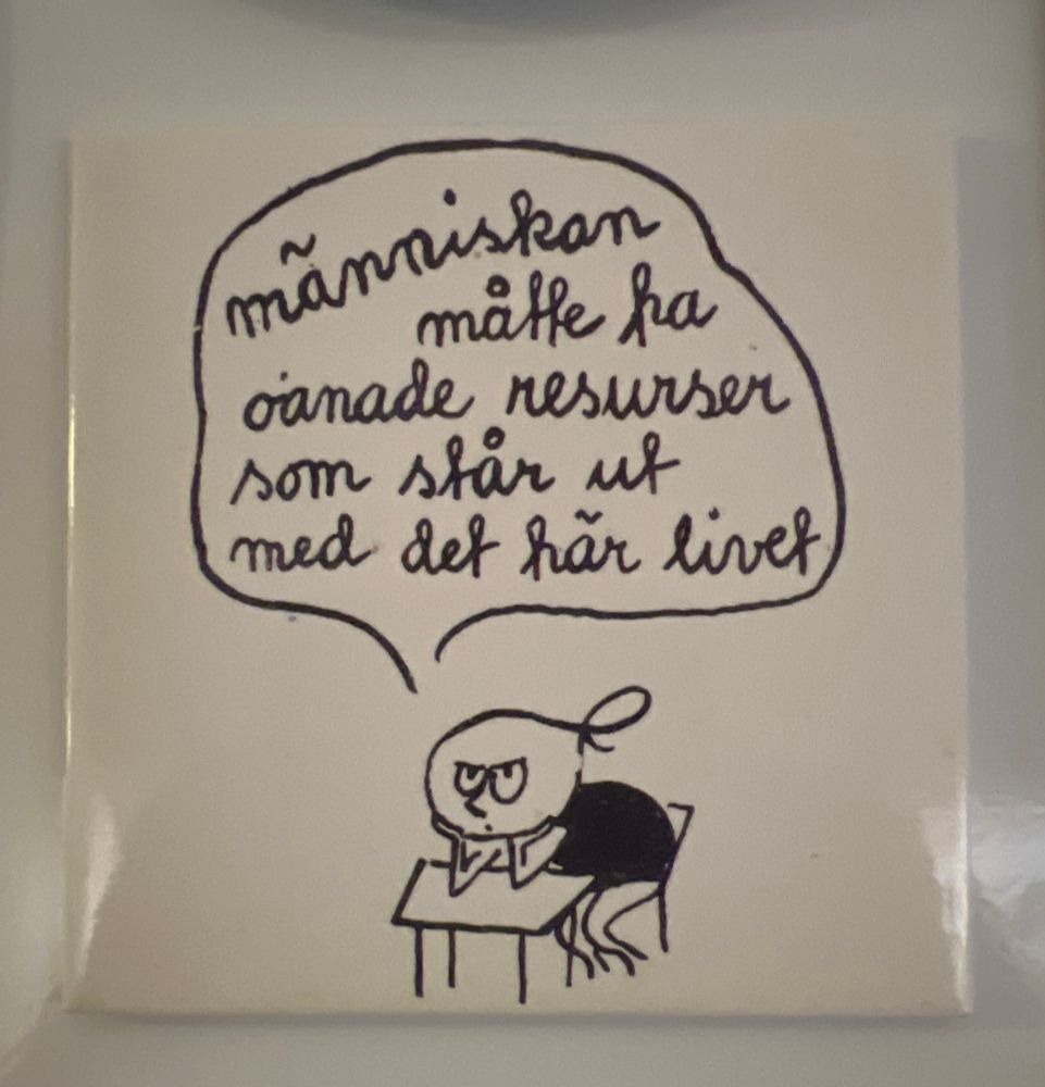 En kylskåpsmagnet med just den texten och en person lutad över ett bord med huvudet i händerna