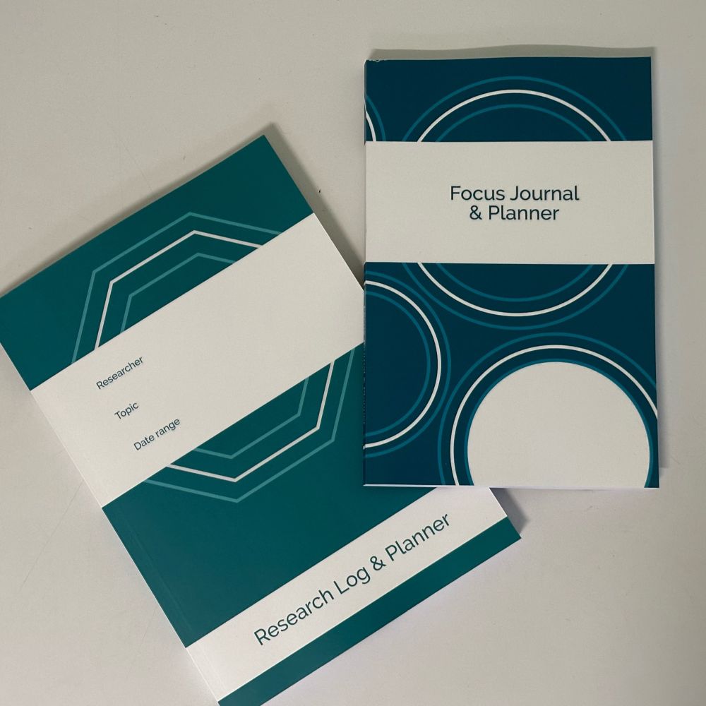 Two journals, a slightly larger teal-coloured one titled Research Log & Planner (with prompts to write the researcher, topic and date range) and a dark blue one titled Focus Journal & Planner.