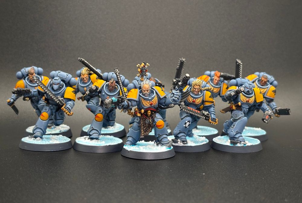 Space Wolf Blood Claw minis painted in blue and yellow with a black background.
