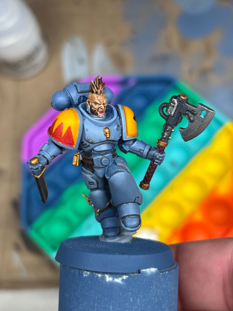 Space Wolf mini painted in front of a rainbow paint pallet that’s also a fidget.