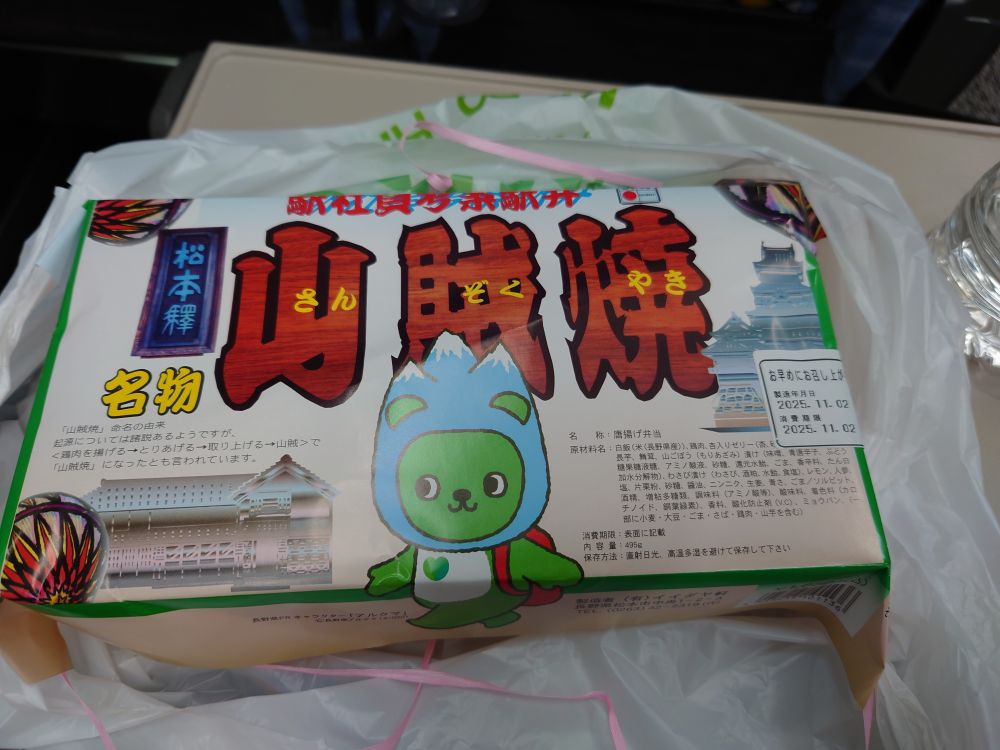 松本駅 山賊焼弁当のパッケージ
真ん中に山の被り物を被ったあるくま(長野県のゆるキャラ、緑のくま)が描いてある