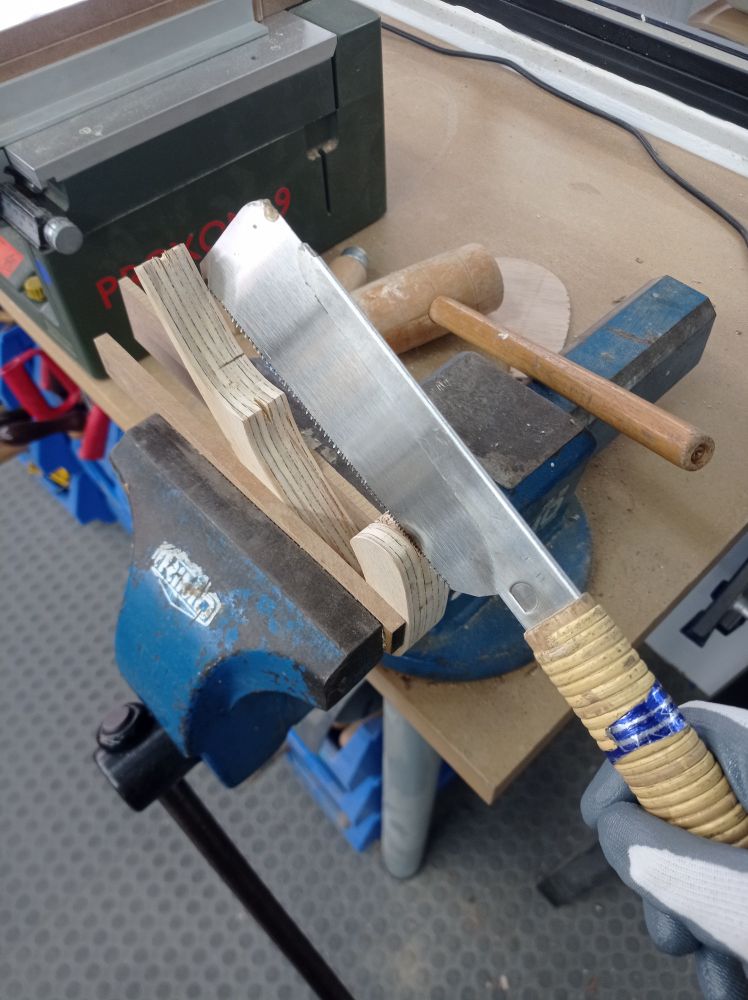 serrucho japonés siendo usado sobre una pieza de madera