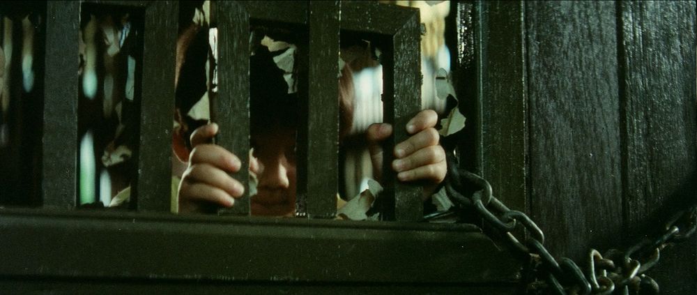 The Kid tests the bars of a locked door 