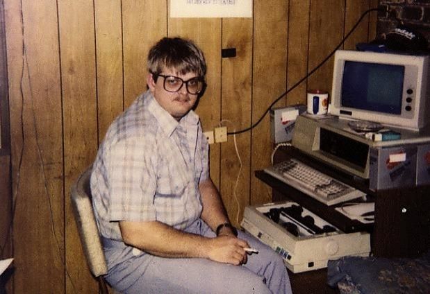 Geek à lunette seul devant un vieil ordinateur