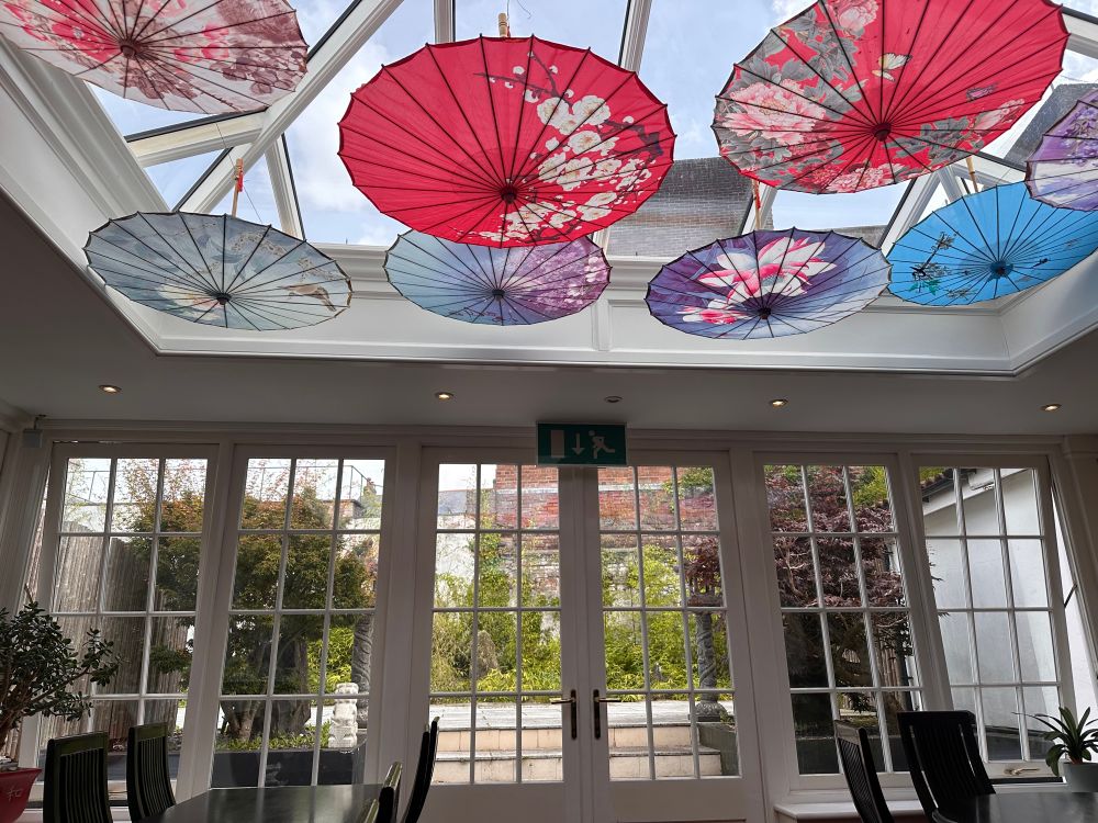 Photo of the interior of a pretty Chinese restaurant showing parasols on the ceiling 
