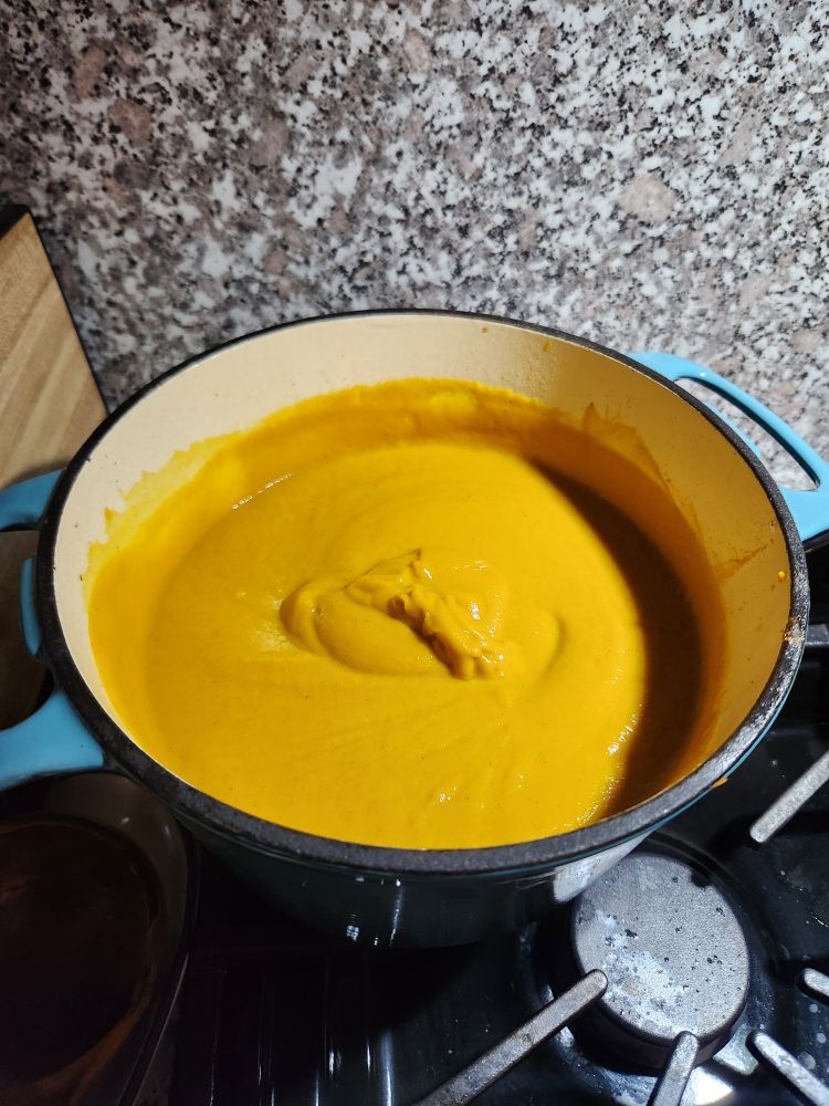 Butternut squash soup in a Dutch oven on a stovetop 