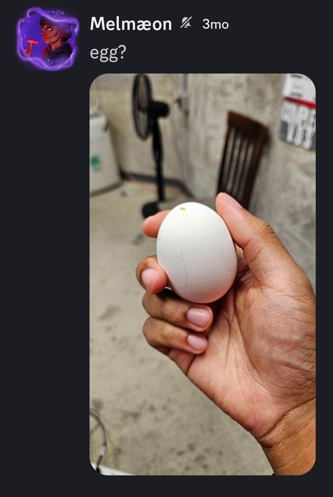 A picture of me holding a hard boiled egg with light cracks in its shell.