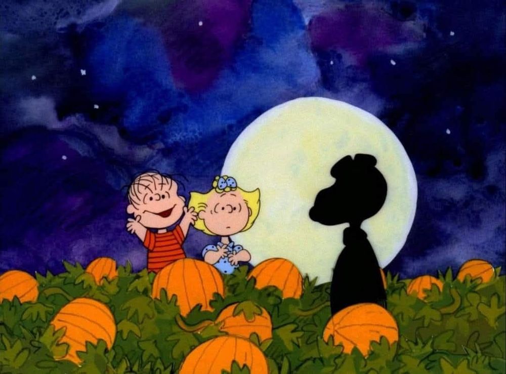 Linus & Sally from the Peanuts cartoon are in a pumpkin patch with the shadow of Snoopy rising up in front of a fulll moon