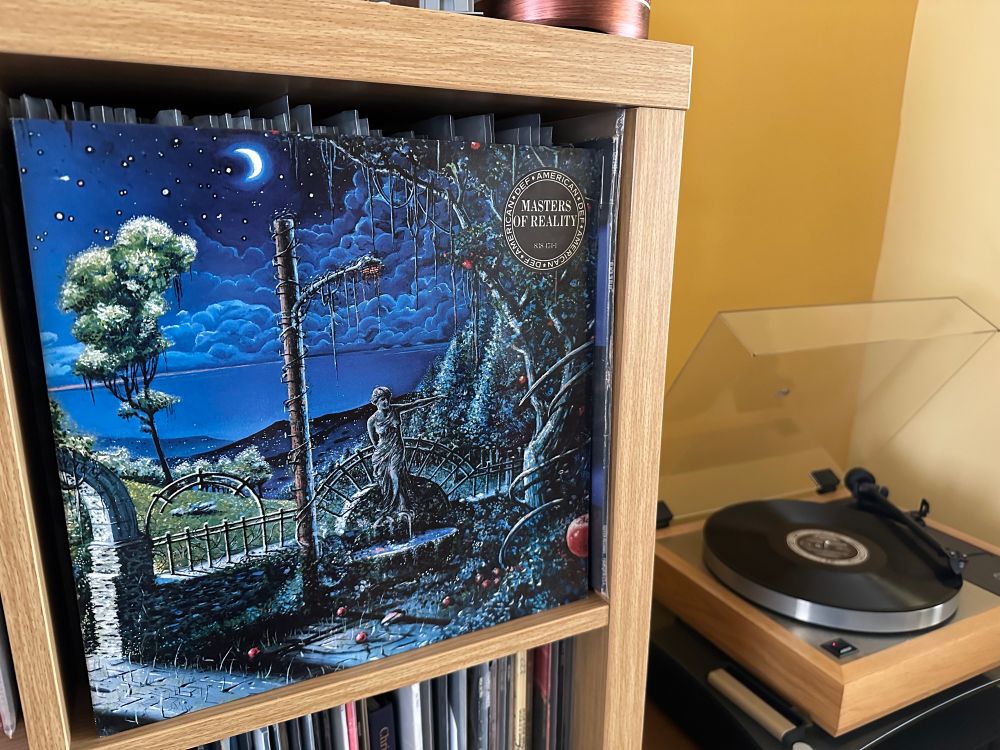 Cover of the debut album by The Masters of Reality.  It depicts a gothic garden in the evening with an overgrown fountain and an apple tree.