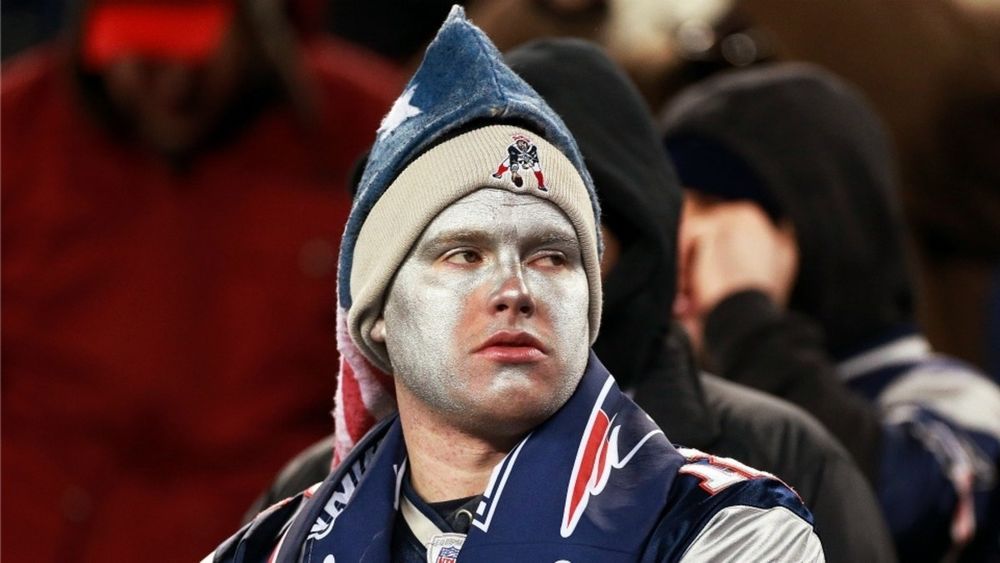 Sad patriots fan with silver face paint rubbing off.