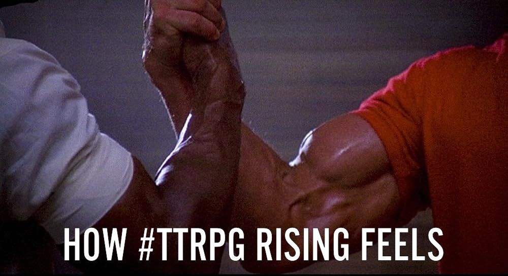 A screenshot of the iconic scene from the 1987 masterpiece, Predator, where Dutch and Dilon shake hands and through the power of their friendship and enormous muscles, heal the world. At the bottom of the image is the text "How TTRPG Rising Feels".  