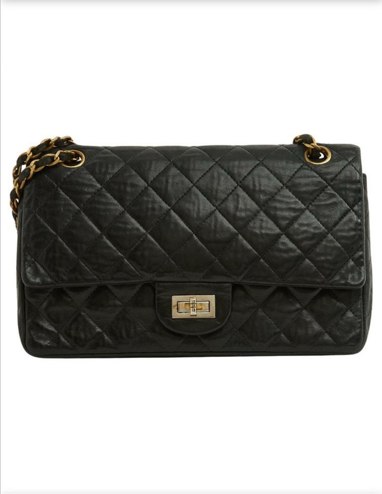 1960s Chanel 2.55 medium size purse in black. White background.