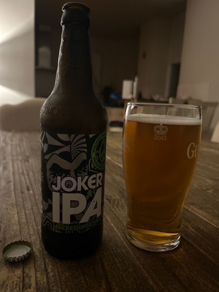 This is a photo of a Joker IPA bottle next to a full pint glass. 