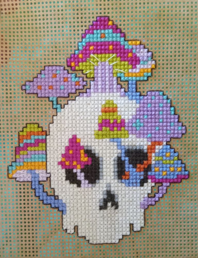 Cross stitched skull with striped mushrooms growing out of it. Pattern courtesy of Jodi at Satsuma Street. 