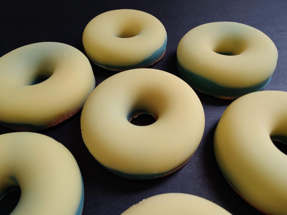 Six doughnut shaped soaps with yellow tops and some green and orange underneath, scented with a lemon verbena scent