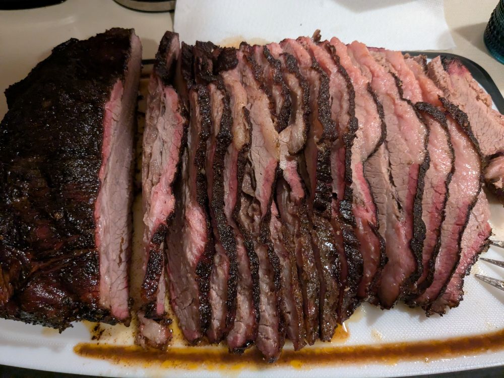 A giant smoked brisket cut up on a cutting board