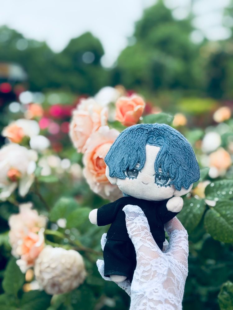 白ベースの薔薇を背景にぬいぐるみが写っています