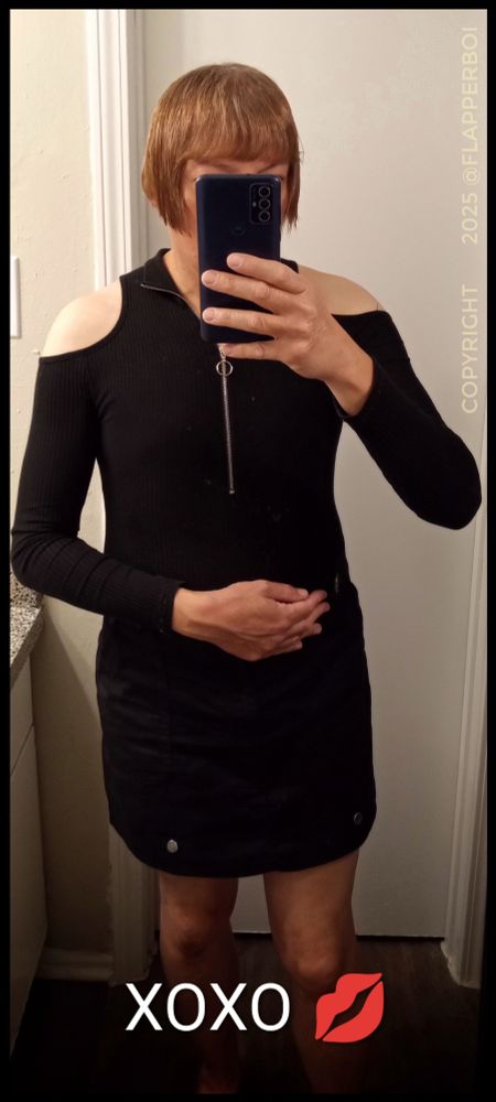 Photo of femboy with a brown reddish Flapper style haircut, wearing a black cold shoulder bodysuit with a black pencil mini skirt.