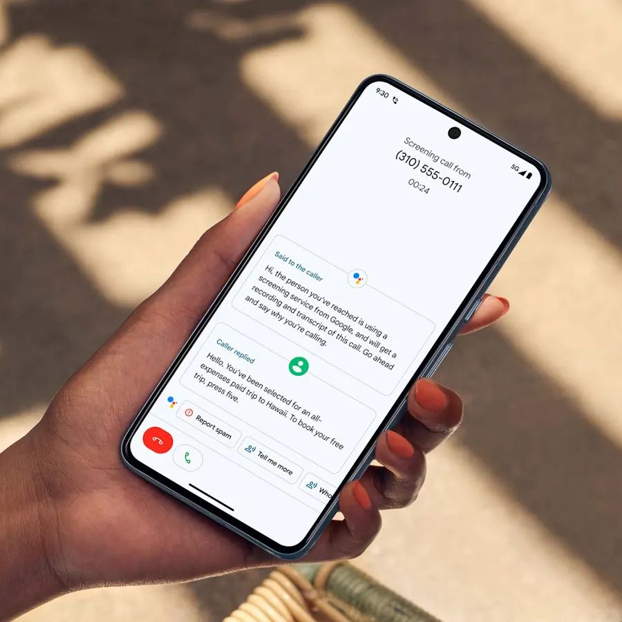 A hand holding a phone, on the screen is the call screening feature from Google. It shows a transcript of the conversation between the caller and the pixel assistant.