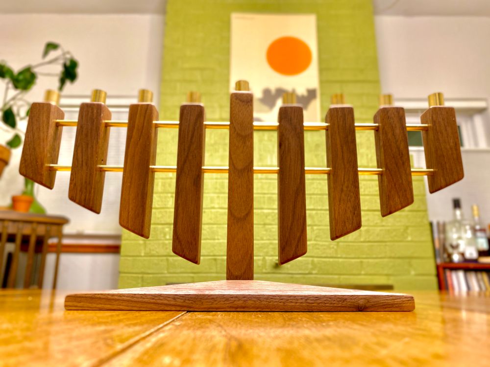 Walnut and brass menorah with brass candleholders on top. Linear geometric design with clean angled bottoms. 