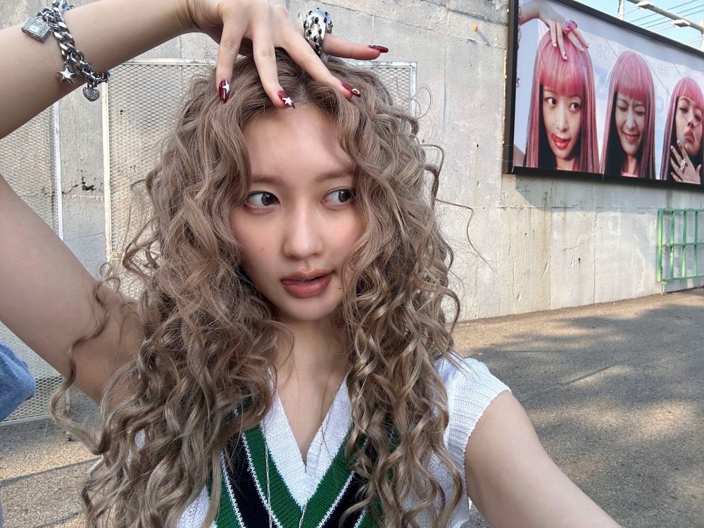 gaeul from ive with a hand in her head, looking sideways