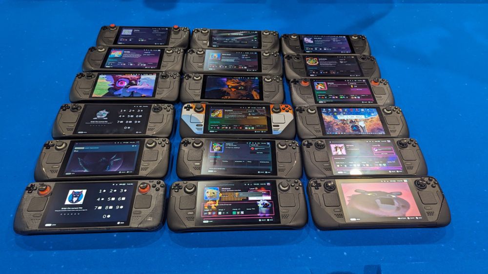 18 Steam Decks aligned in a 6x3 grid on a table