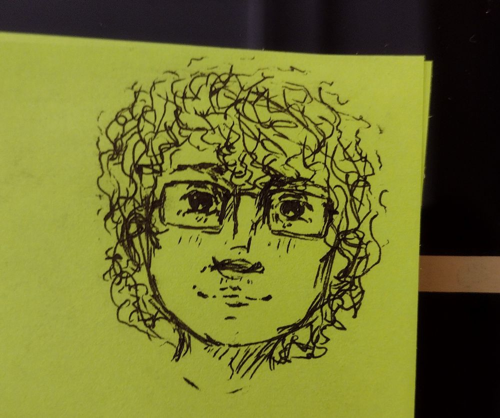 Loose pen doodle of myself from the neck up: a young white man with curly hair and large rectangular glasses, all drawn in the corner of a bright green post-it note.