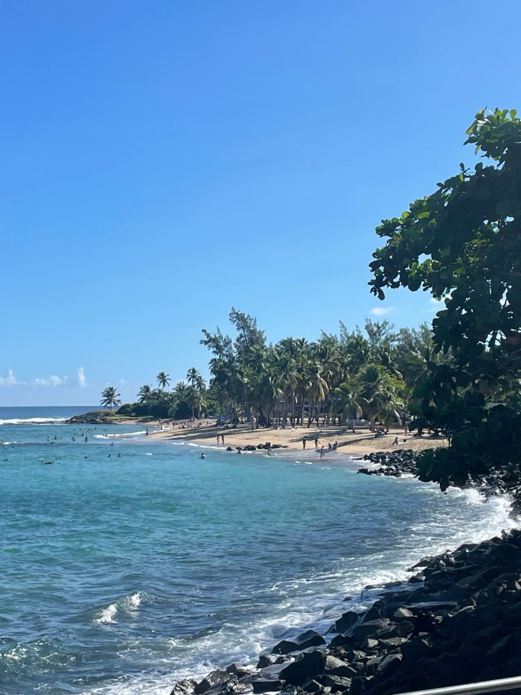 View of Playa Escambron from the west with rocky shores framing a stretch of sandy beach in between 