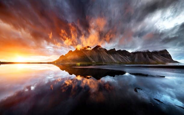 Scenic image of an Icelandic mountain at sun set under a dramatic cloud-filled sky.