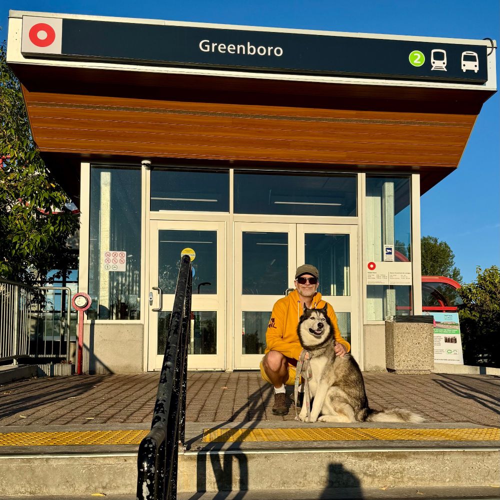 Our first stop of the day was to sit in front of the entrance of the O-Train Station at Greenboro. This was… okay, and he would rather be walking, but he didn’t know we were going to make him do this three more times, so at this point, he’s still smiley dog.