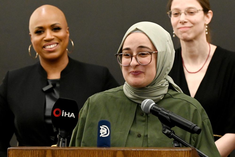 Rümeysa addresses reporters at a press conference with Rep Ayanna Pressley to her left 