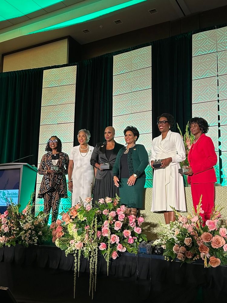 Rep. Ayanna Pressley stands on stage to be recognized alongside other Congresswomen members of the links. 