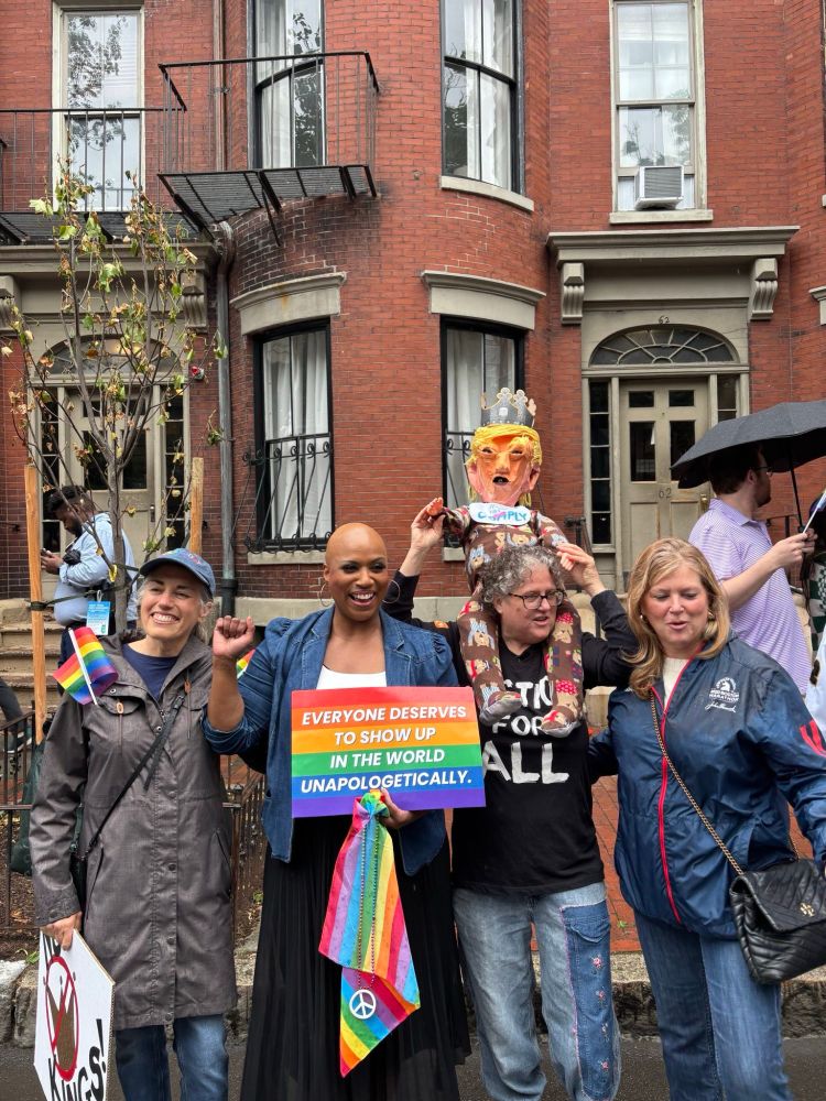 Ayanna Pressley holds up a fist and laughs in a photo at the Boston pride parade and No Kings rally