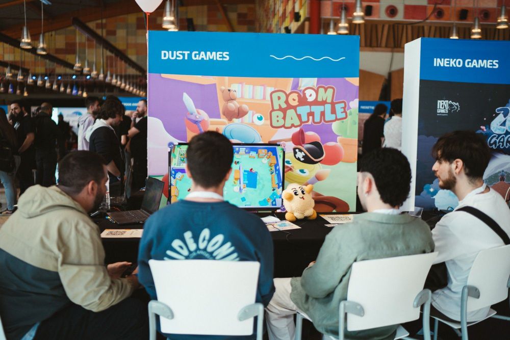 a game stand featuring Room Battle from Dust Games and people playing the game during Guadalindie 2024
