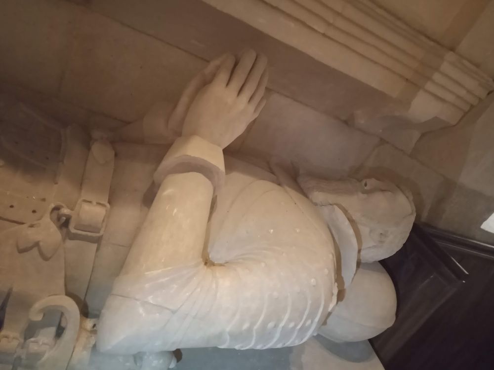 Detail or upper male effigy wear half-plate armour.