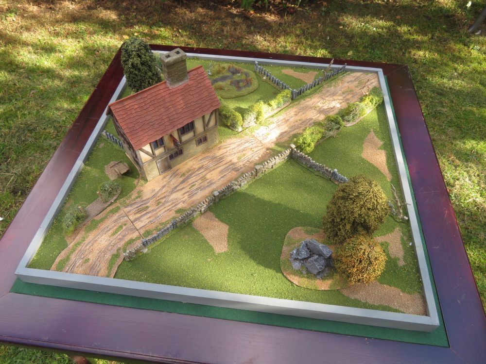 Terrain board for 28mm miniatures.

2’ x 2’ / 600 x 600mm board with some scratch-built trackways, K&M type trees and an Inn building (front view).