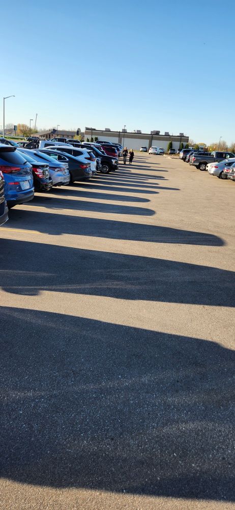 Cars in parking lot with very long shadows