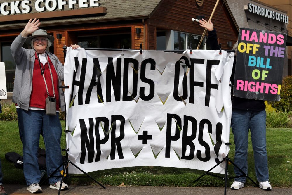 Two waving demonstrators hold up a banner between them which reads, "HANDS OFF NPR + PBS!" The demonstrator o the right also holds up a sign which reads "HANDS OFF THE BILL OF RIGHTS!"

At 4pm on May 19th, 2025, demonstrators in Vancouver, WA gathered at the intersection of Mill Plain and Chaklov to protest the destruction of essential social services by US President Donald Trump's fascist regime.