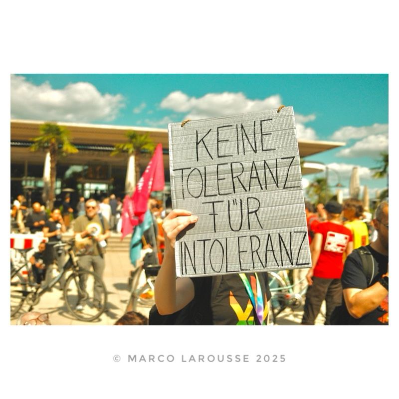 Eine Demonstrantin hält ein Schild mit dem Text: „Keine Toleranz für Intoleranz“.