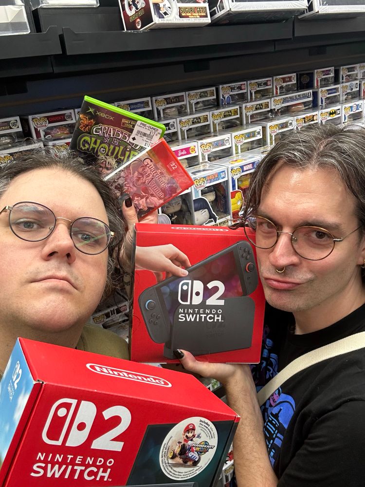 Myself and best bud Jordan in front of the Funko pop wall at GameStop holding the Switch 2 box