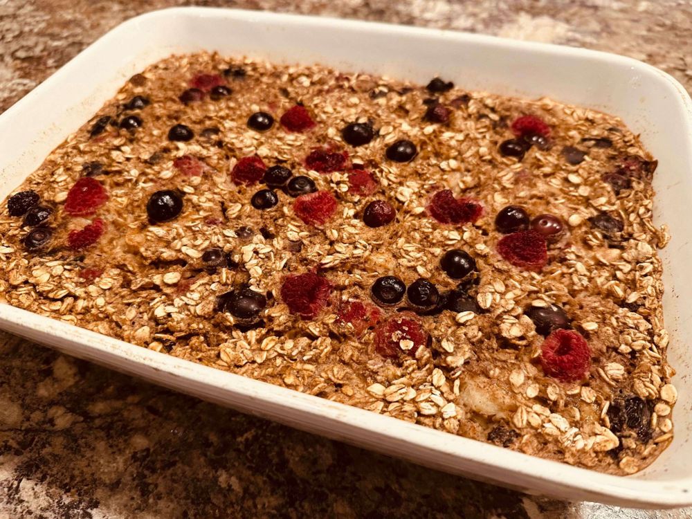 Blueberry and raspberry baked oats in a porcelain baking tray.