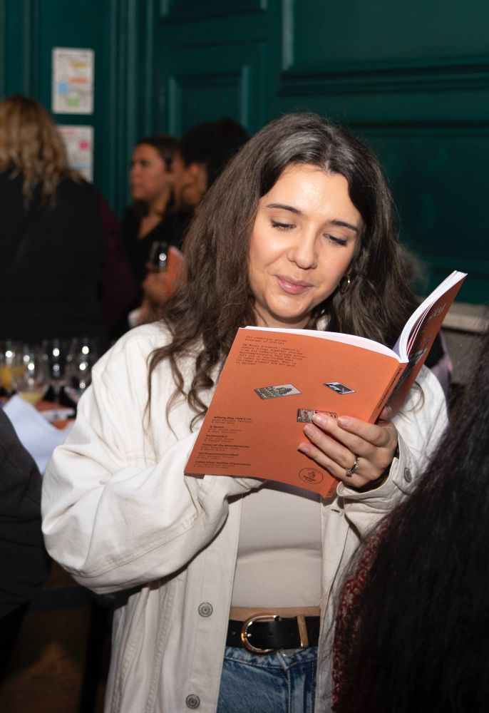 A lady in her 20s reading ‘60 Miles presents: Community Comics’ as part of the book launch